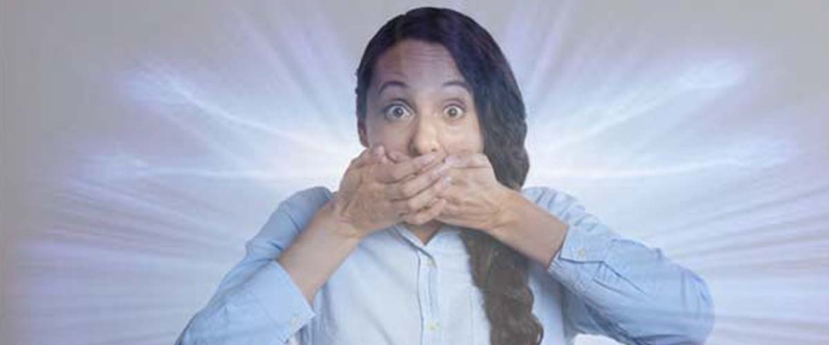 young woman with amazed expression covers mouth as aura spreads forth